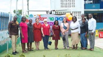 Teachers from North Carolina stand in front of a sign in Ghana celebrating the end of the school year.